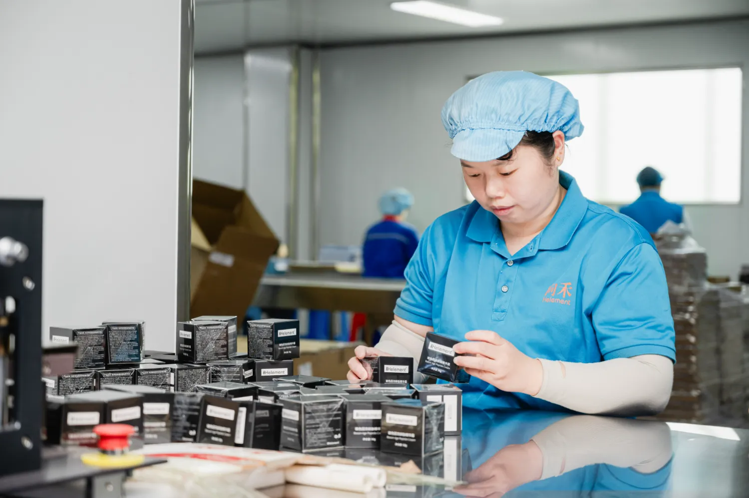 Factory worker packaging product boxes at the workbench