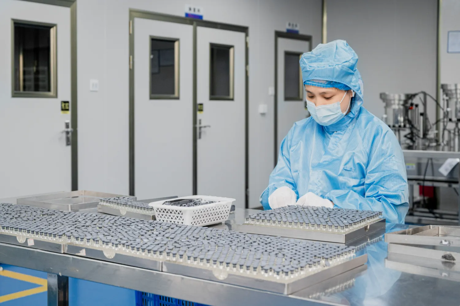 Lab technician handling sample vials in a cleanroom